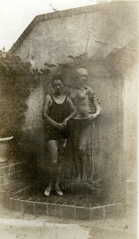 <em>Unidentified woman standing by the fountain in the garden on the south side of the Byrne-Reed House. Courtesy of the Reed family.</em>