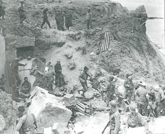 Rudder's command post on Pointe du Hoc, late morning, June 8, 1944. Rudder is at top center, watching the German prisoners. Photo courtesy of the U.S. National Archives. Rudder's Command Post